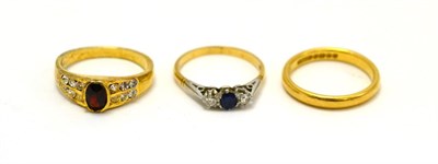 Lot 195 - A 22ct band ring, an 18ct gold sapphire and diamond three stone ring together with a dress ring (3)