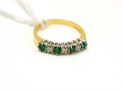 Lot 409 - An emerald and diamond half hoop ring