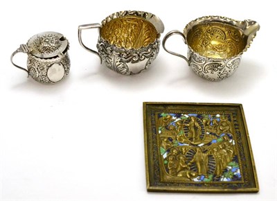 Lot 421 - A silver cream jug, another similar, a silver mustard and a Medieval style enamelled panel