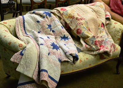 Lot 486 - Circa 1930's striped reversible quilt in cream and floral printed cottons, 260cm by 215cm; an...