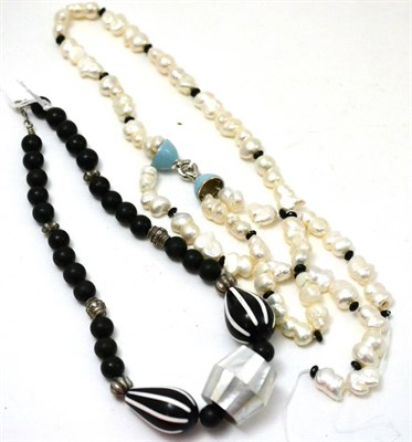 Lot 524 - A pearl necklace, a black bead and mother-of-pearl necklace (2)