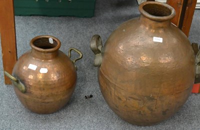 Lot 1092 - A large twin-handled copper vessel together with a smaller example (2)