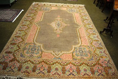 Lot 1218 - Kirman Carpet, South East Persia, the pale mushroom field centred by an anchor medallion framed...