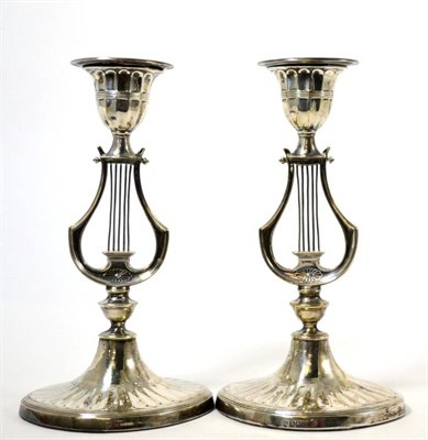 Lot 119 - A pair of silver loaded lyre candlesticks