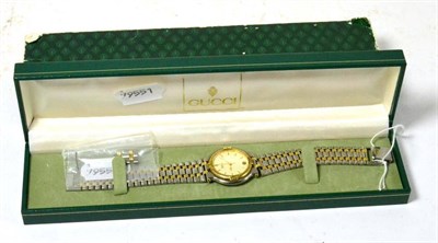 Lot 181 - A cased Gucci wristwatch, stainless steel with gilt links, date aperture