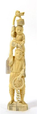 Lot 228 - A late 19th century Japanese carved ivory okimono of a man with a child upon his shoulders...