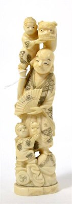 Lot 229 - A late 19th century Japanese carved ivory figure of a mask seller with two children, 21.5cm