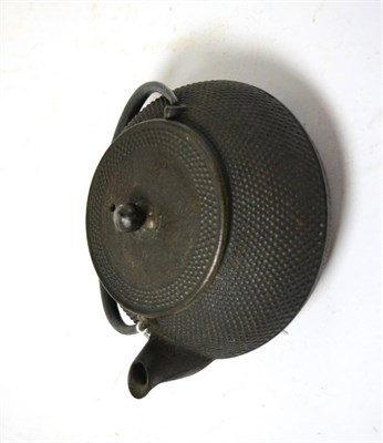 Lot 382 - A Japanese signed iron teapot and cover