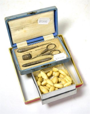 Lot 389 - An ivory necklace, late 19th/early 20th century with a cased silver sewing set (2)