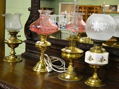 Lot 409 - Four oil lamps, one converted for electricity