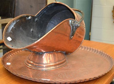 Lot 1011 - A copper coal scuttle and a large copper charger