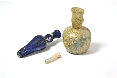 Lot 15 - A Hellenistic or Roman dark blue glass alabastron, 8.5cm high, with a Roman glass bottle and...