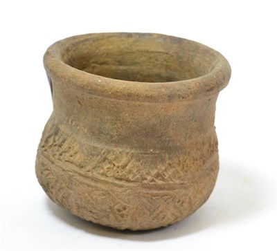 Lot 33 - An early terracotta vessel, possibly Bronze Age, with continuous stylised geometric decoration...