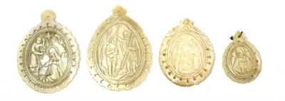 Lot 72 - A collection of four Continental Medieval style mother-of-pearl pendants, carved in relief with...