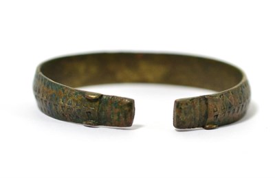 Lot 85 - A Viking period bronze bangle, circa 8th-12th century AD, of typical triangular punch work...