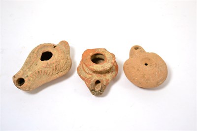 Lot 94 - A Roman terracotta oil lamp, circa 1st-2nd century A.D, of typical form with raised decoration,...