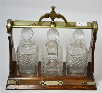 Lot 120 - A Staniforths patent three bottle oak and plated tantalus, by Fenton Bros, Sheffield with...