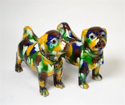 Lot 125 - A pair of Chinese ";egg and spinach"; glazed standing dogs, late Qing Dynasty, 17cm high by...