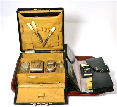 Lot 168 - A green leather glove and accessory case, black leather brush set and a hinged leather mounted...