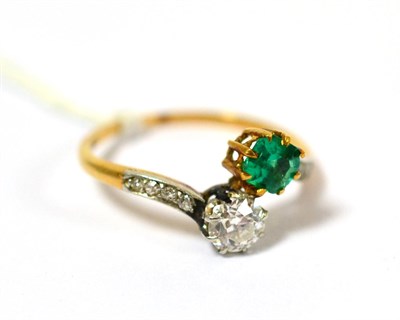 Lot 206 - A diamond and emerald set crossover ring with diamond set shoulders