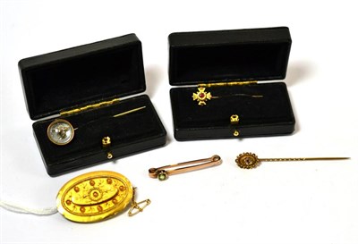 Lot 234 - A mourning brooch, stamped '15ct', a peridot pin, two pins and a reverse intaglio fox mask pin (5)