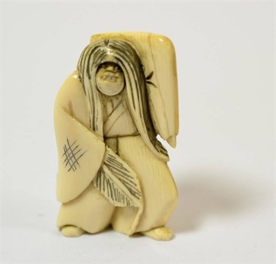 Lot 347 - A Meiji period carved ivory netsuke of a figure with changing face, signed