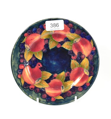 Lot 386 - A William Moorcroft Pomegranate pattern plate, on a green/blue ground, impressed factory mark...