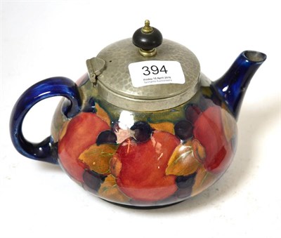 Lot 394 - A William Moorcroft pewter mounted Pomegranate pattern teapot, on a mottled green ground, blue...