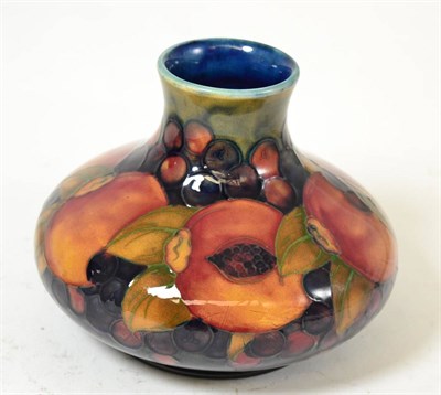 Lot 397 - A William Moorcroft Pomegranate pattern vase, on a blue ground, impressed factory marks, blue...