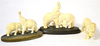 Lot 401 - A group of early 20th century carved ivory animals including two pairs of elephants and a lion (3)