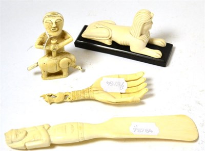 Lot 405 - A group of early 20th century carved ivory including a sphinx Egyptian carved shoe horn, tribal...