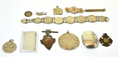 Lot 458 - A group of silver including a vesta, coin bracelet, brooch, fob, medal, medallions, ingot,...