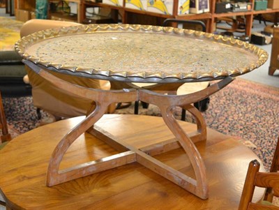 Lot 1017 - A brass table on folding stand