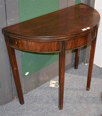 Lot 1021 - A George III mahogany demi lune fold over tea table (a.f.)