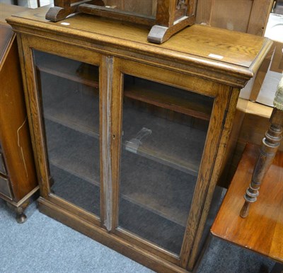 Lot 1042 - An early 20th century glazed oak bookcase, child's chair and standard lamp