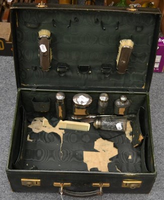 Lot 1101 - A black leather dressing case with silk lining containing some silver mounted fittings, two...