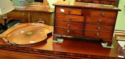 Lot 1302 - A mahogany table top chest of drawers together with a mahogany tray (2)