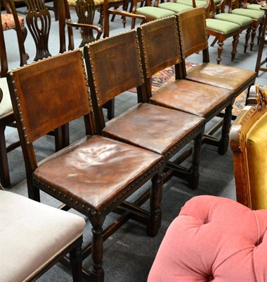 Lot 1324 - A set of four oak dining chairs with tan leather upholstery and brass studding