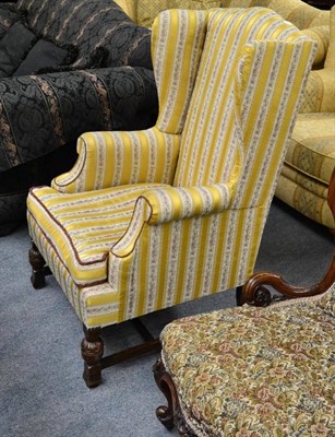 Lot 1331 - A 19th century oak framed wing armchair in a yellow striped upholstery