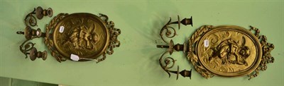 Lot 1419 - A pair of oval brass wall sconces with embossed cherub decoration