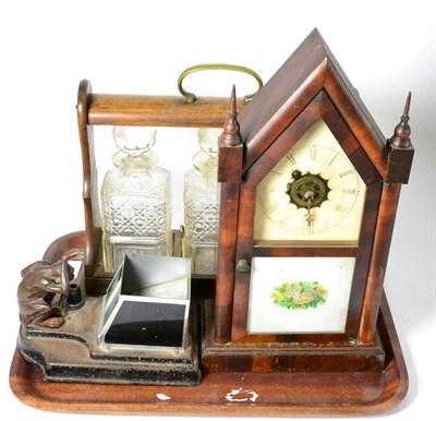 Lot 29 - An early 20th century oak three decanter tantalus, an art deco monkey cigarette dispenser and...