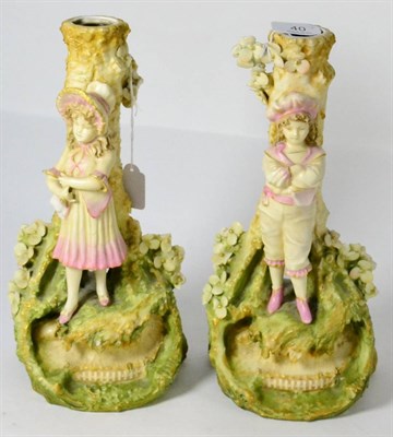 Lot 40 - A pair of Royal Dux style figural candlesticks, girl and boy on naturalistic bases (2) (both a.f.)