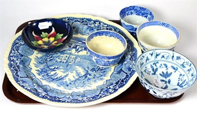 Lot 180 - Four blue and white bowls, a blue and white charger and a small Moorcroft footed bowl