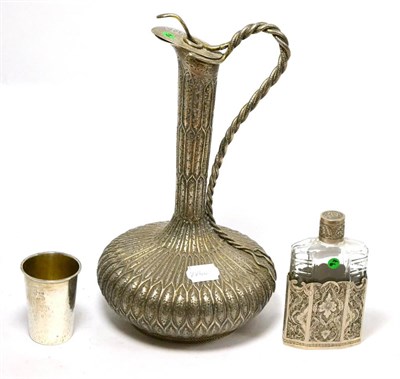 Lot 188 - An Indian white metal ewer, small beaker and a white metal floral engraved drinking flask