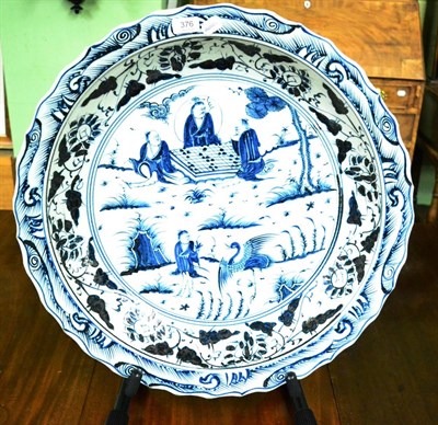 Lot 376 - A Chinese blue and white charger decorated with figures in a landscape