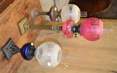 Lot 1102 - A cranberry glass oil lamp on brass Corinthian column stepped base; together with a Bristol...