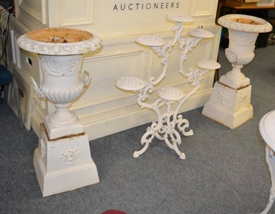 Lot 1176 - A pair of cast garden urns on stands