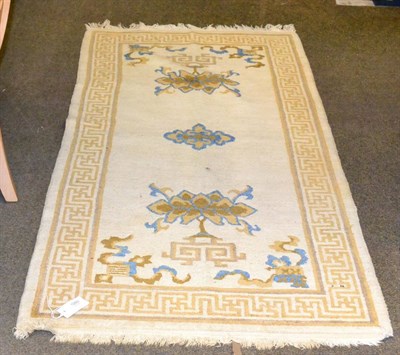 Lot 1280 - A Tibetan/Nepali rug, the cream field with Buddhist symbols enclosed by swastika borders, 185...