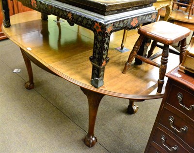 Lot 1289 - An extending walnut dining table on claw and ball feet