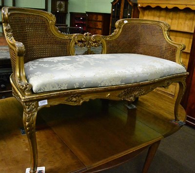 Lot 1290 - A small French caned settee in carved giltwood, circa 1900, with squab